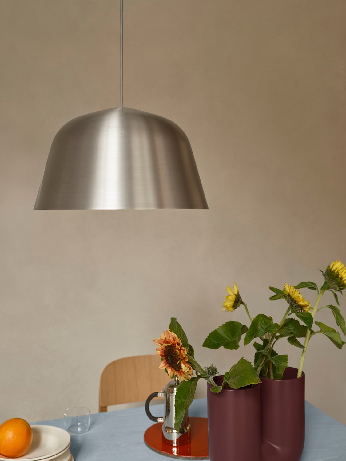 /cdn-cgi/image/width=1500,quality=85,format=auto/globalassets/content-media/images/01.-lifestyle-images/january-26/ambit-pendant-brushed-steel-40-kink-vase-deep-red-re-norm-table-light-blue-workshop-chair-oak-low-res.jpg