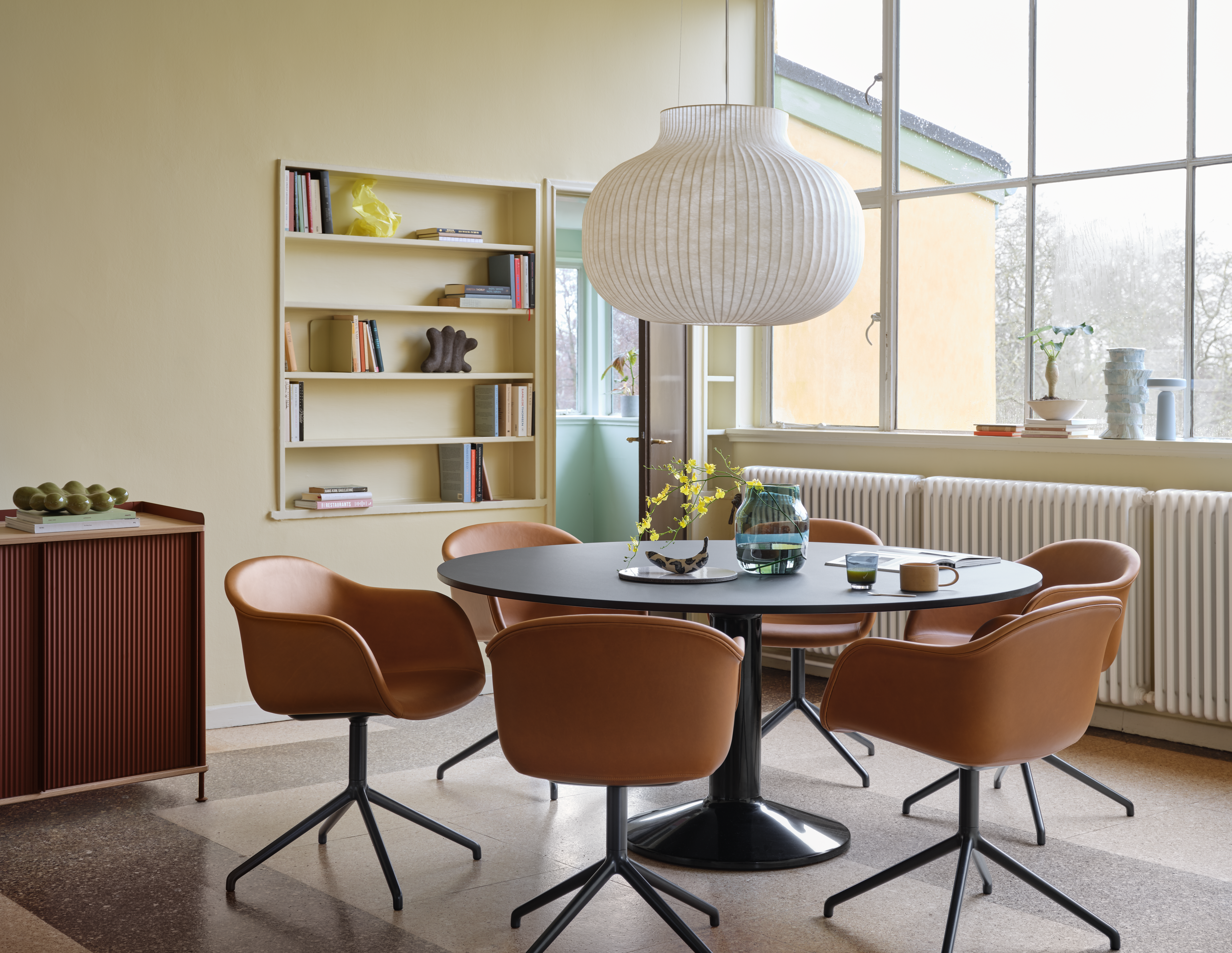 Midst Table &#216;160 cm in Black - Fiber Armchair Swivel Base in Refine Leather Cognac/Black - Strand Pendant Lamp &#216;60 cm in White - Silent Vase &#216;20 cm in Dark Green - Enfold Sideboard 100x45 H85 cm in Deep Red - Ease Portable Lamp in Light Blue 