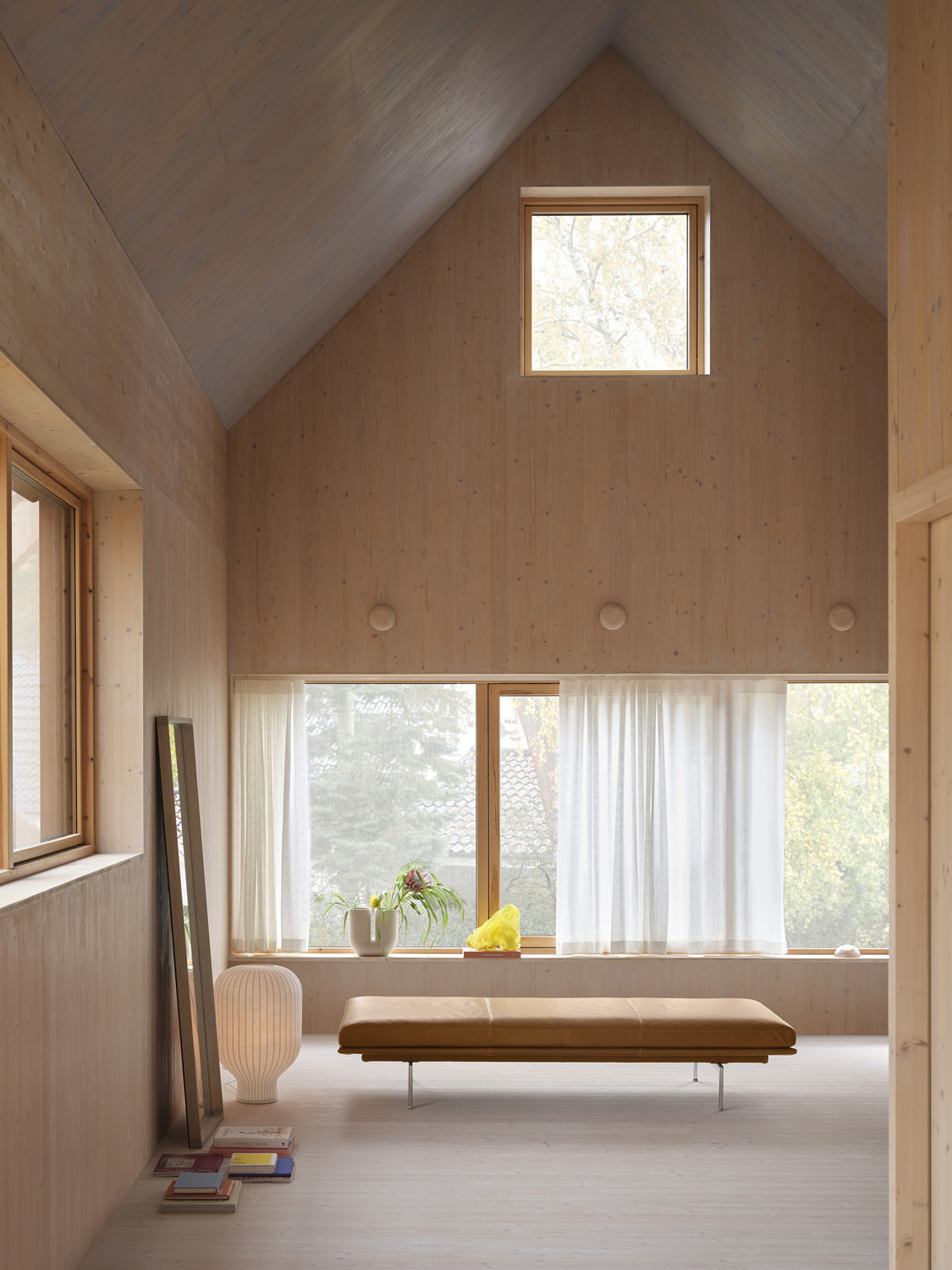 Luxurious Outline Daybed in cognac leather, complemented by a Strand table lamp and a sculptural Kink vase. A chic addition to contemporary living rooms or offices.