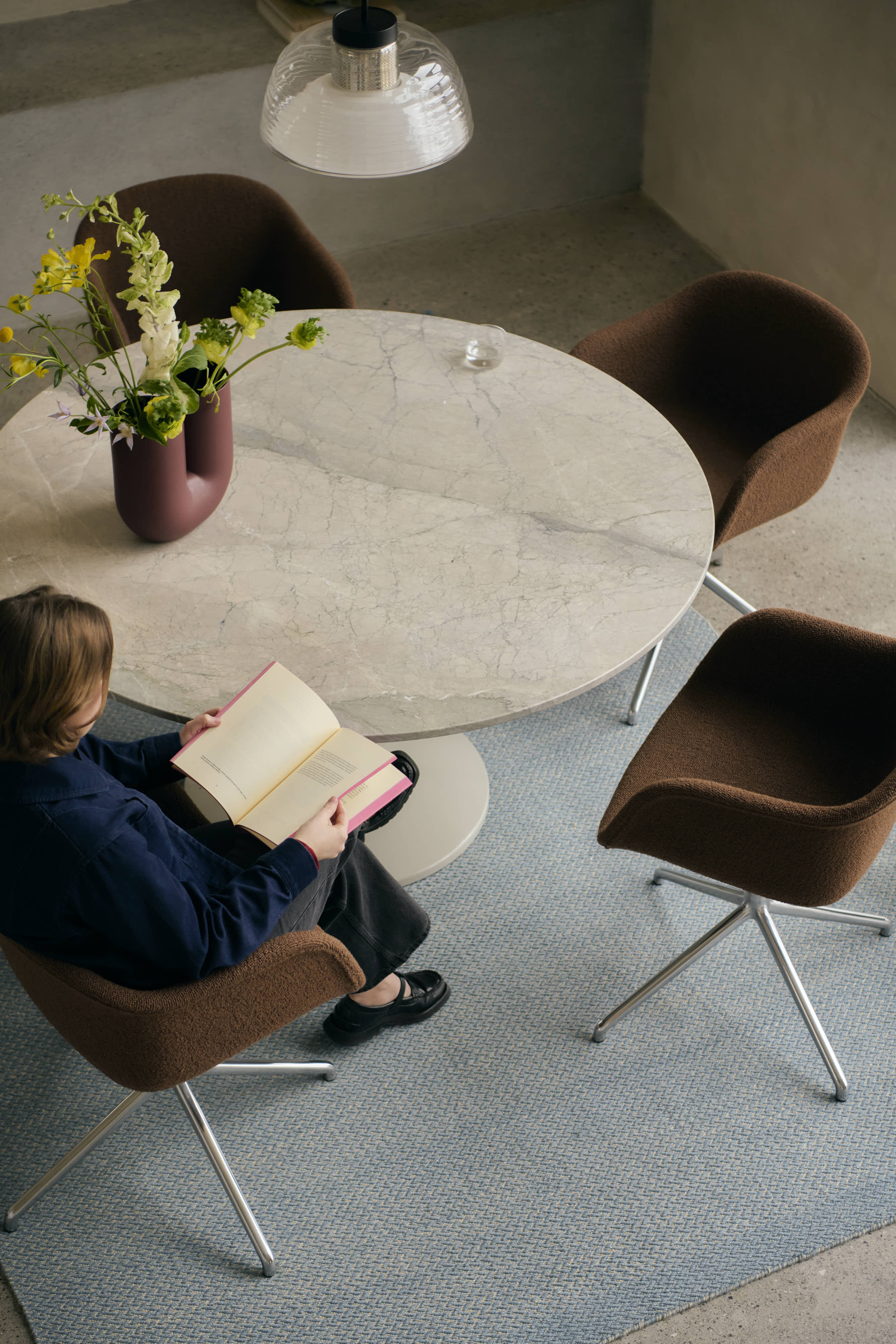 A simple, modern dining table with a marble surface, surrounded by soft brown dining chairs, creating a warm and stylish dining setting.
