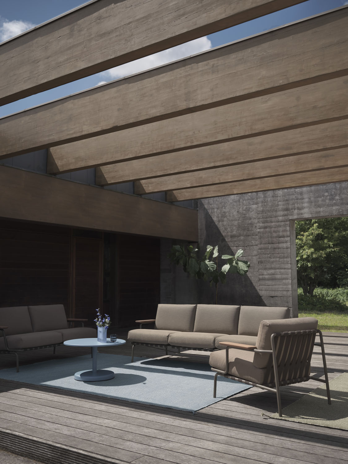 Image of a 3-seated Settle sofa in a nice sun-lit outdoor space.  