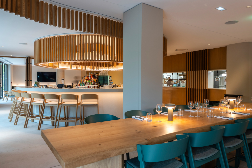 Interior view of Horizon Resort Massane in France featuring Muuto furniture, including the Ease Portable Lamp, Cover Bar Stool, and Cover Side Chair, creating a modern and welcoming hotel atmosphere.