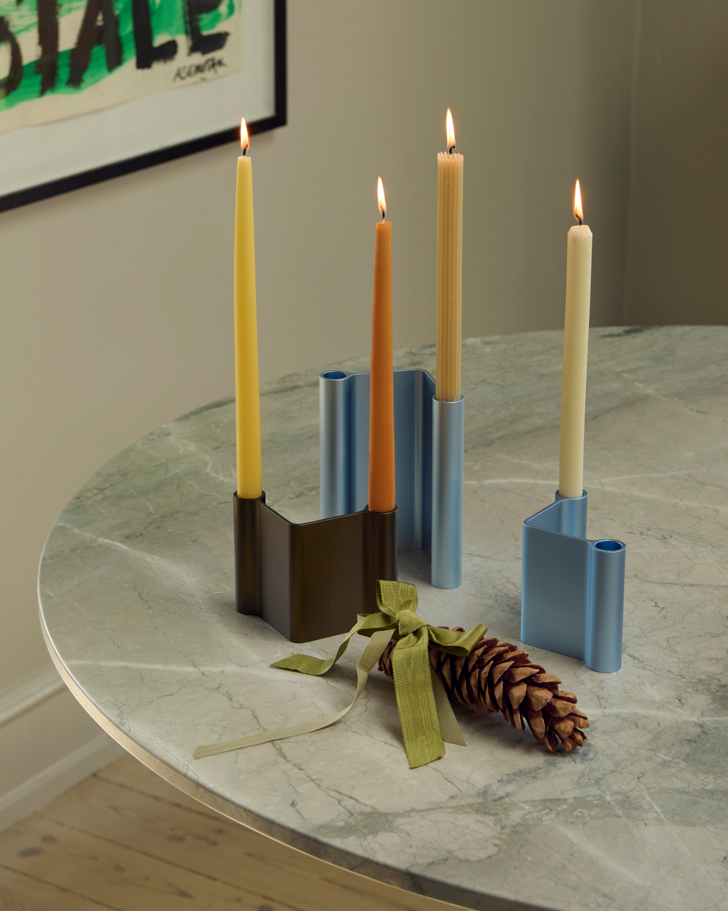 The Midst Table in grey marble styled with Pair Candleholders in brown and light blue, creating a calm atmosphere with subtle color contrasts and minimalist details.