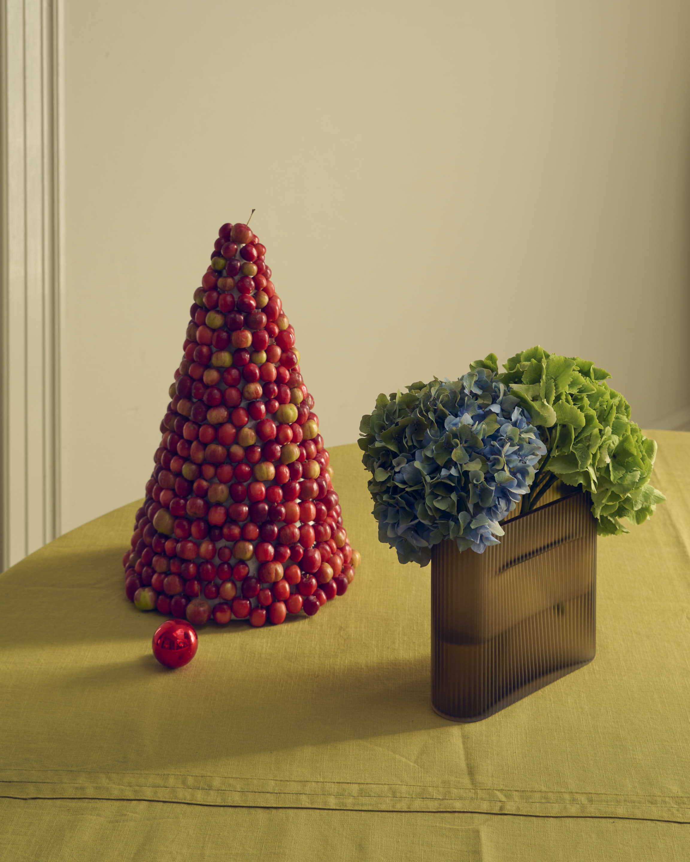 The Ridge Vase frosted glass in taupe, styled in a calm holiday setting with soft natural light and seasonal elements.